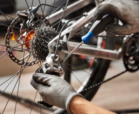 Male mechanic working in bicycle repair shop using tools